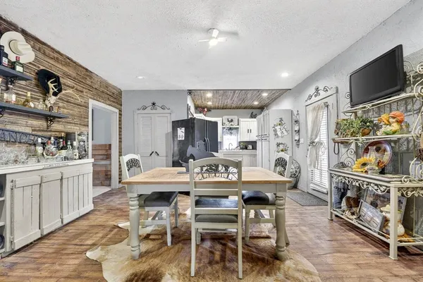 a view of a dining room with furniture a kitchen and chandelier