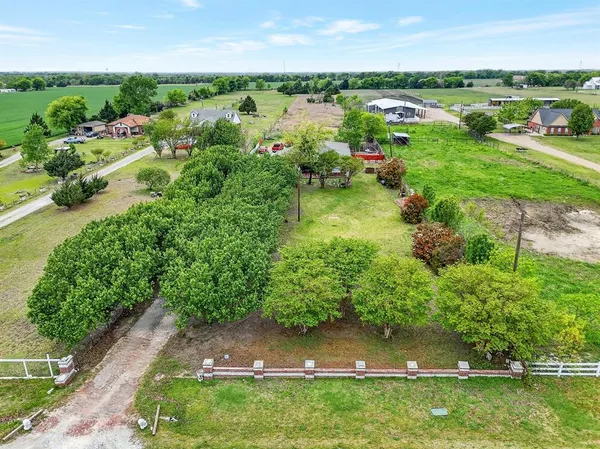 an aerial view of residential houses with outdoor space and trees