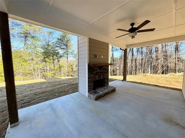 a view of an empty room with fireplace and a window