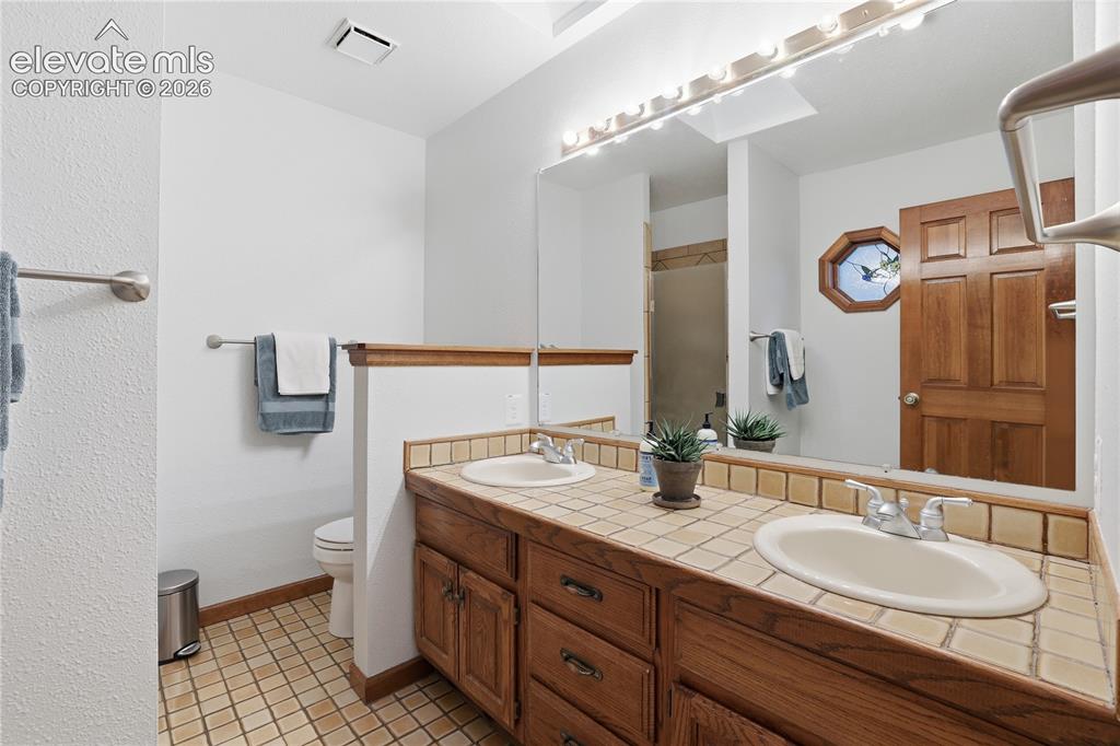 18190 Forest View Road Monument, CO 80132 - Photo 23 of 50 a bathroom with a double vanity sink and a mirror