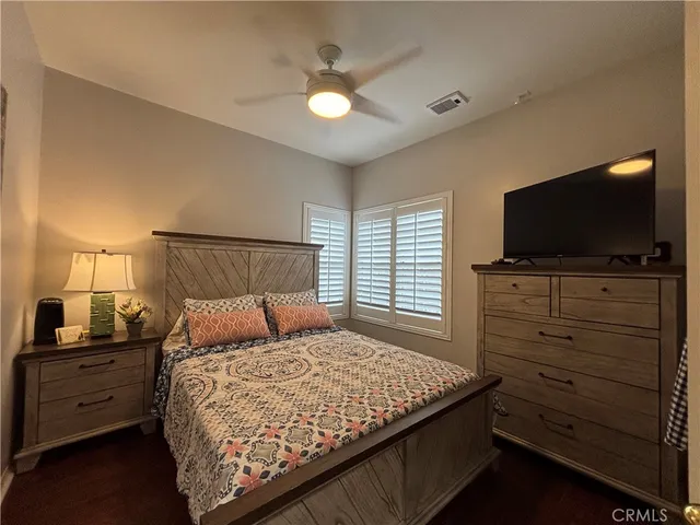 a bedroom with a bed and a flat tv screen on dresser