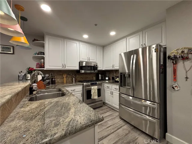a kitchen with a refrigerator sink and stainless steel appliances