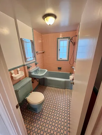 a bathroom with a toilet a sink and a mirror