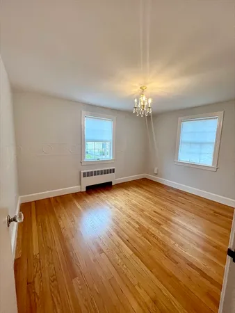 a view of a room with wooden floor and chandelier