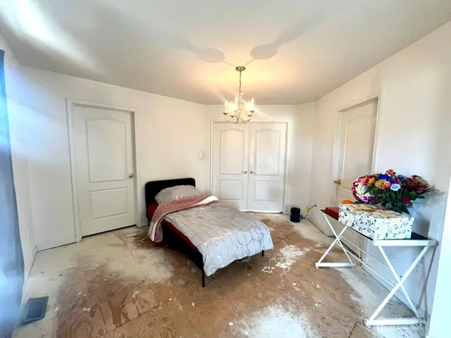 a bedroom with a bed and a chandelier