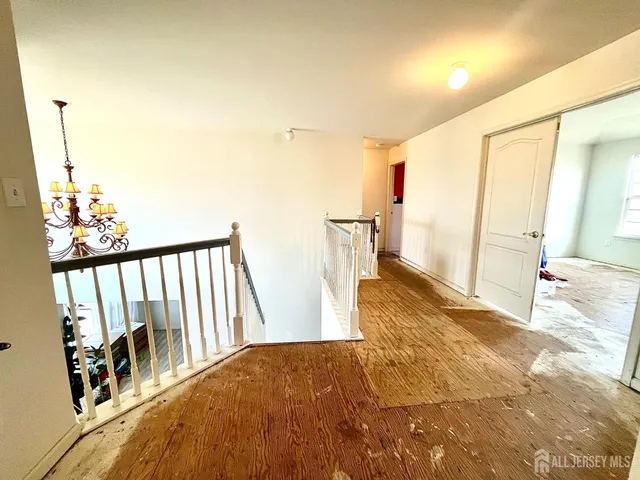 a view of a bedroom with wooden floor and windows