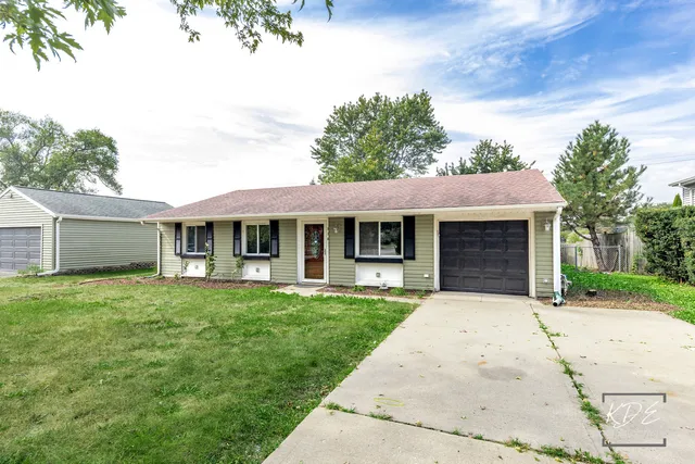 a front view of a house with a garden and trees