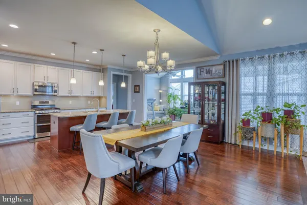 a kitchen with stainless steel appliances granite countertop a kitchen island hardwood floor sink and stove