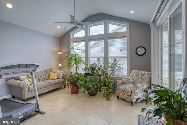 a bedroom with a bed couch chandelier and a window