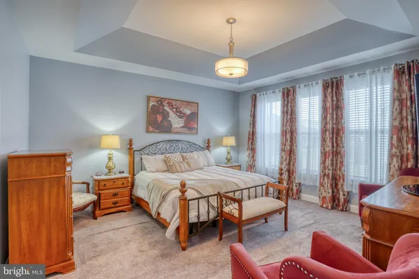 a bedroom with a bed and a lamp on dresser