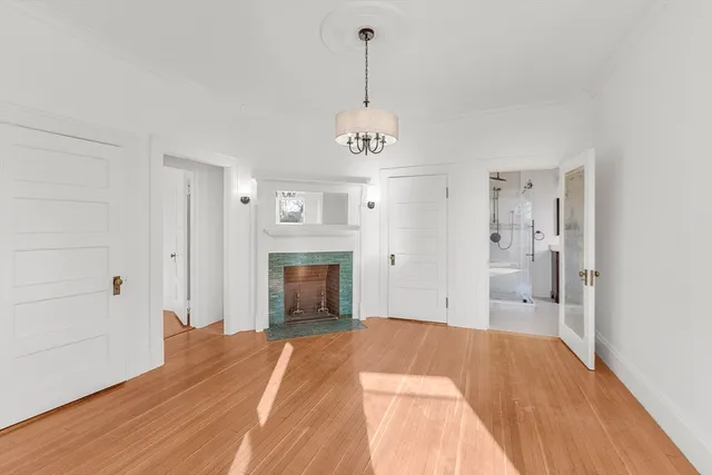a view of a livingroom with wooden floor a ceiling fan and windows