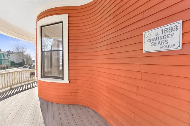 a view of a hallway with wooden floor and windows