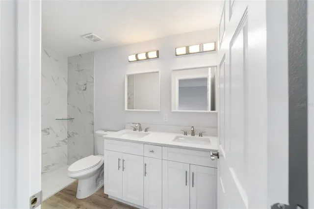 a bathroom with a toilet a sink and mirror