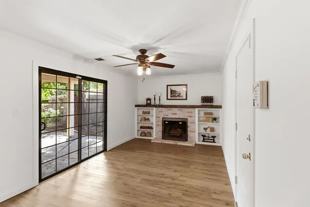 a view of an empty room with window and fire place