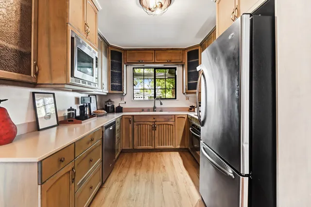 a kitchen with stainless steel appliances granite countertop a refrigerator and a sink