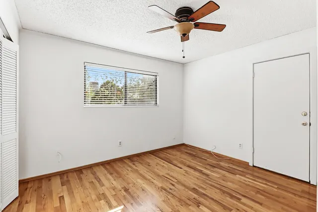 an empty room with a window and a ceiling fan