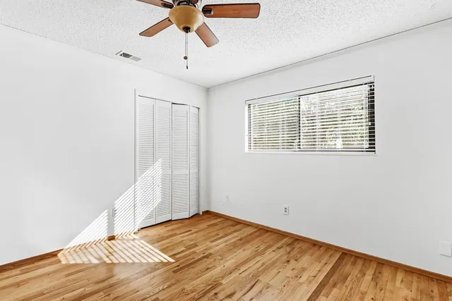 a view of a livingroom with wooden floor and a ceiling fan