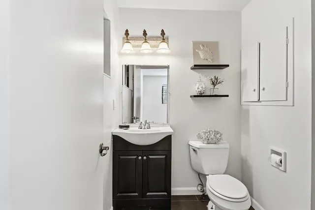 a bathroom with a toilet sink and mirror