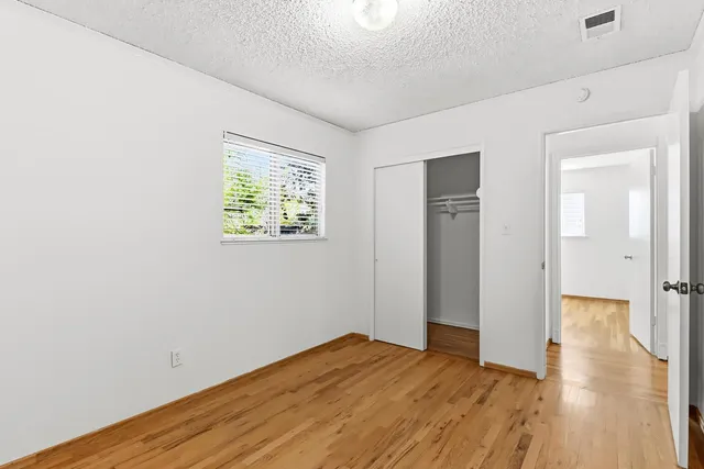 a view of empty room with wooden floor