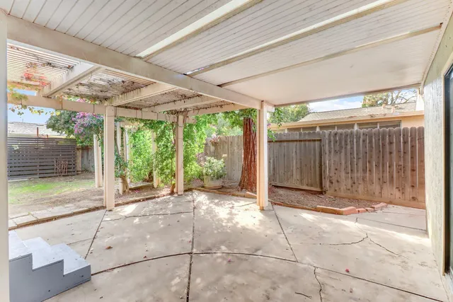 a backyard of a house with basket ball court and floor to ceiling window