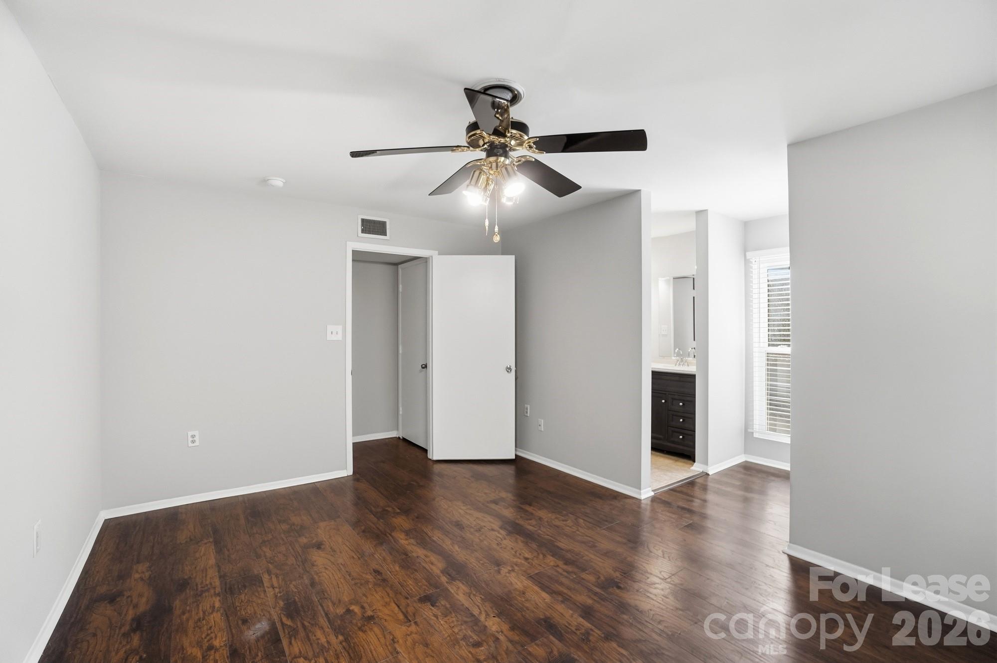 4948 Sardis Road, Unit C Charlotte, NC 28270 - Photo 13 of 25 a view of an empty room with wooden floor and a ceiling fan