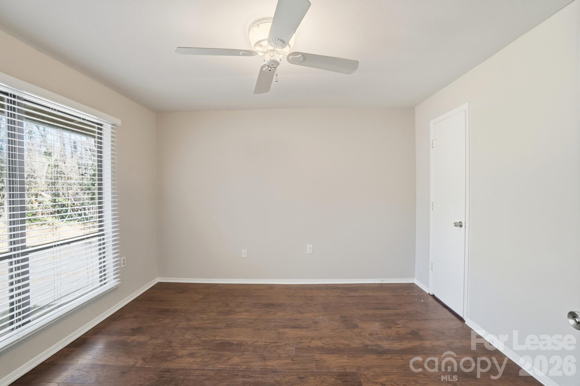 4948 Sardis Road, Unit C Charlotte, NC 28270 - Photo 19 of 25 an empty room with a window and a ceiling fan