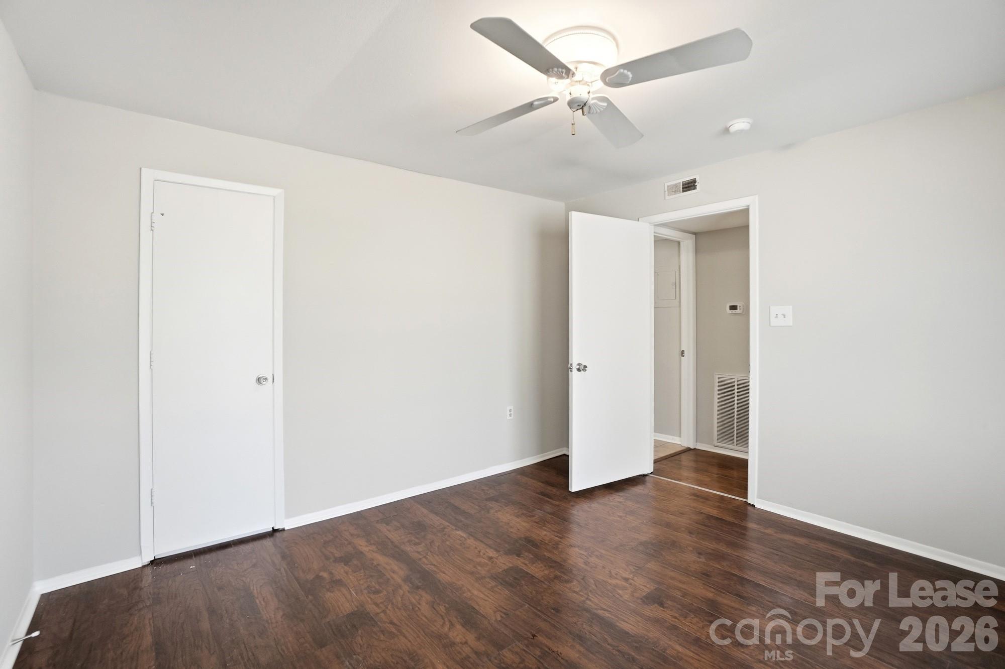 4948 Sardis Road, Unit C Charlotte, NC 28270 - Photo 20 of 25 an empty room with wooden floor and ceiling fan
