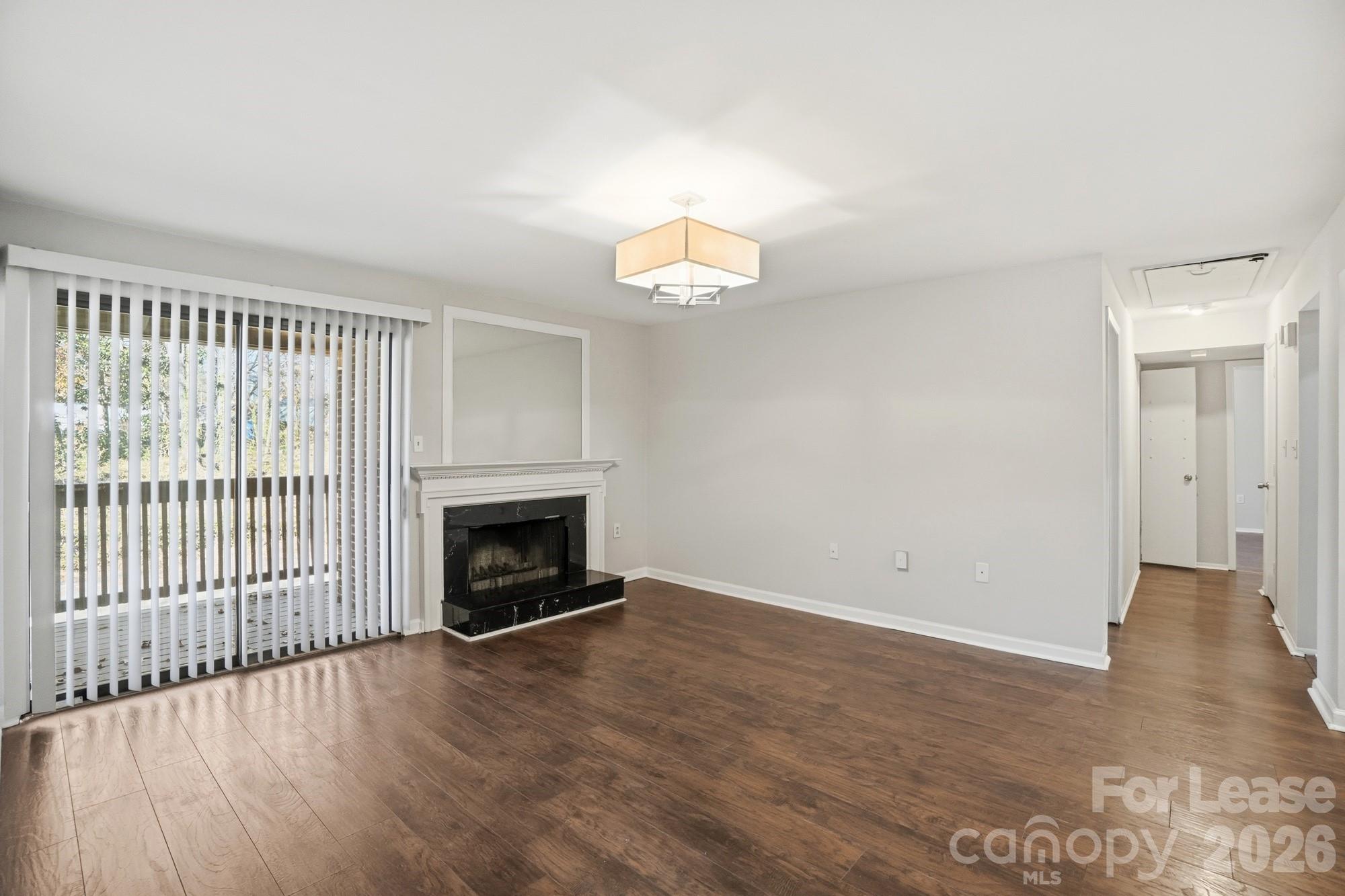 4948 Sardis Road, Unit C Charlotte, NC 28270 - Photo 5 of 25 an empty room with wooden floor fireplace and windows