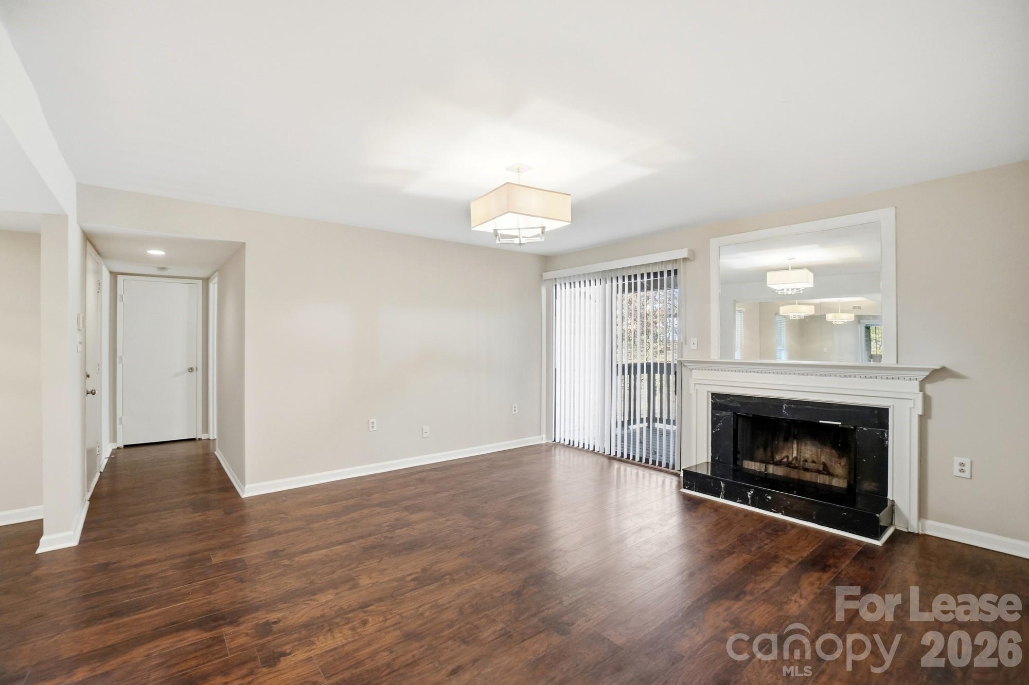4948 Sardis Road, Unit C Charlotte, NC 28270 - Photo 7 of 25 a view of an empty room with wooden floor fireplace and a window