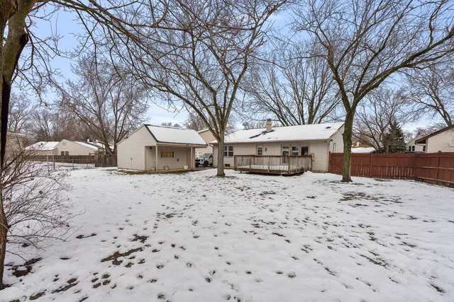 a front view of a house with a yard covered in snow