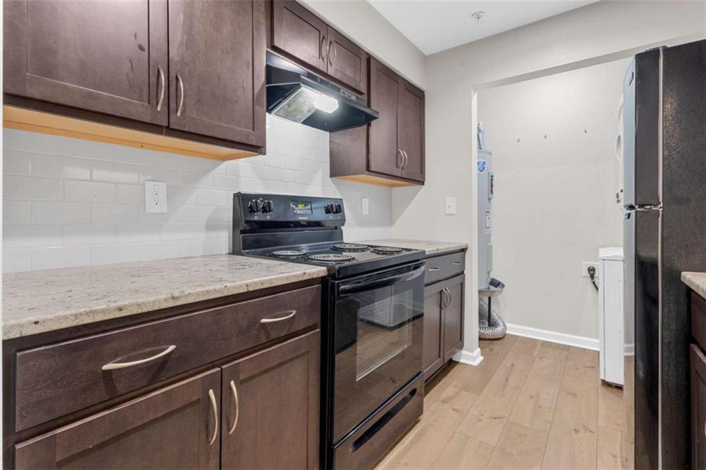 1166 Booth Road, Unit 407 Marietta, GA 30008 - Photo 7 of 18 a view of a kitchen with stainless steel appliances granite countertop a stove and a refrigerator
