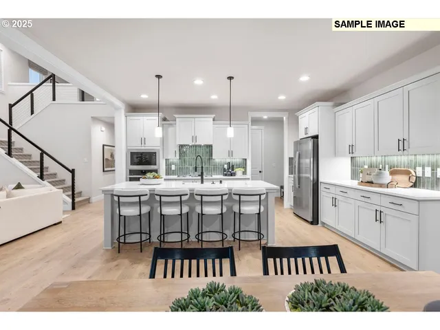 a kitchen with stainless steel appliances kitchen island granite countertop a dining table chairs and white cabinets