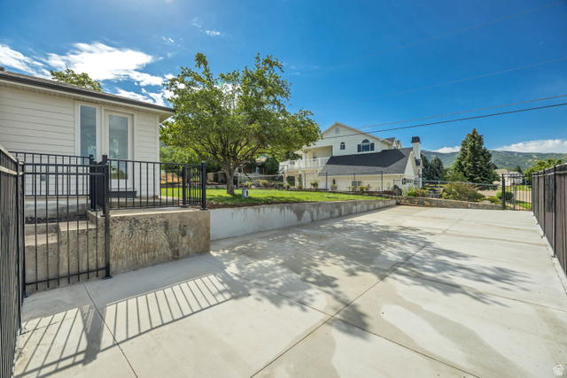 1168 East Center Street Bountiful, UT 84010 - Photo 37 of 38 Expansive concrete driveway framed by black metal fencing