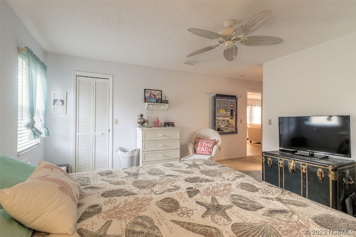 2828 Pine Tree Drive Edgewater, FL 32141 - Photo 17 of 38 a bedroom with a bed and a flat screen tv