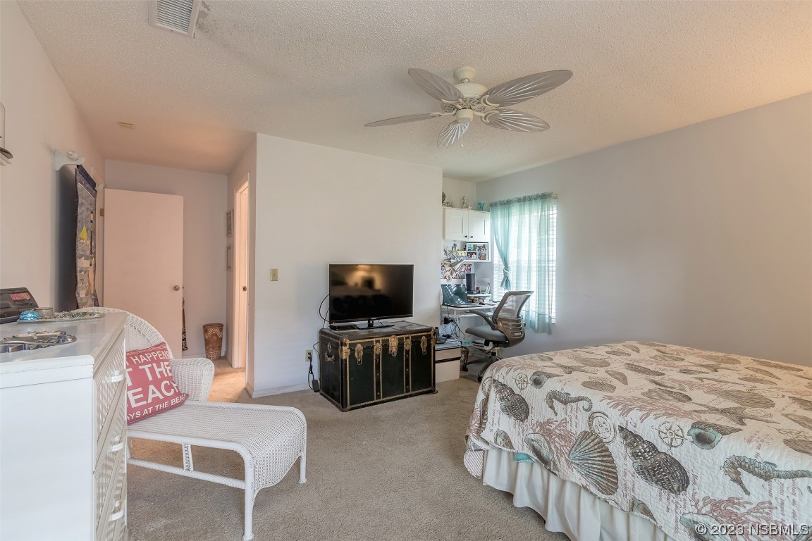 2828 Pine Tree Drive Edgewater, FL 32141 - Photo 18 of 38 a bedroom with a bed and a flat screen tv