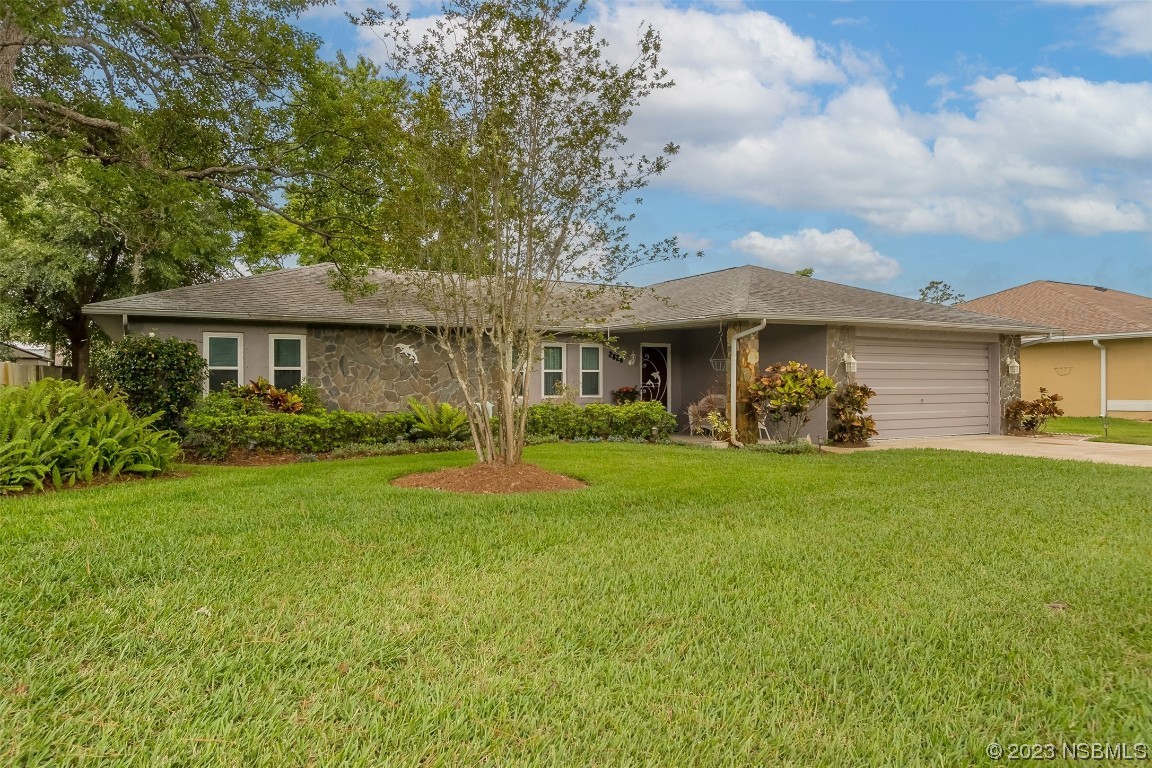 2828 Pine Tree Drive Edgewater, FL 32141 - Photo 2 of 38 a front view of a house with garden