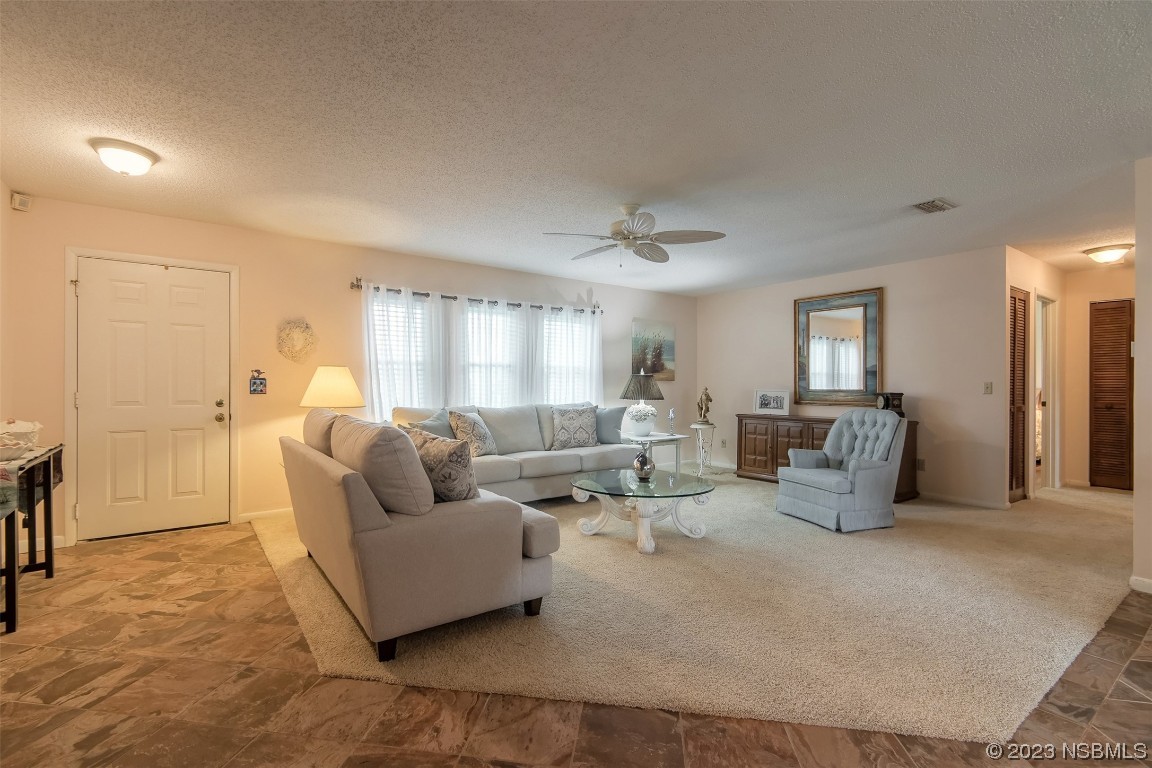 2828 Pine Tree Drive Edgewater, FL 32141 - Photo 8 of 38 a living room with furniture and a chandelier