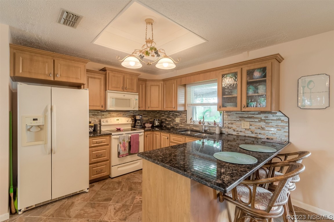 2828 Pine Tree Drive Edgewater, FL 32141 - Photo 9 of 38 a kitchen with stainless steel appliances granite countertop a stove top oven a refrigerator a sink and dishwasher