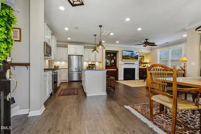 a kitchen with stainless steel appliances kitchen island granite countertop a refrigerator and a stove top oven