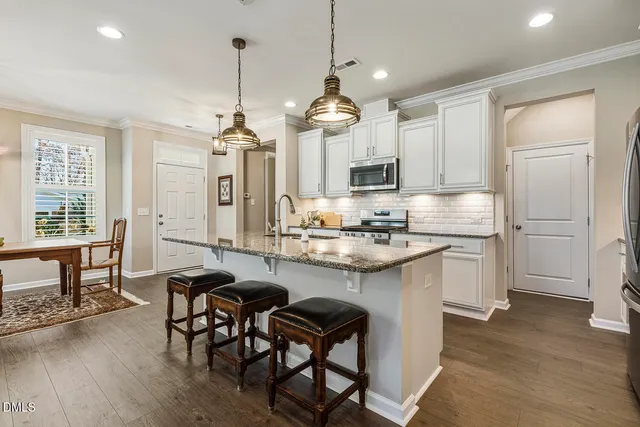 a kitchen with kitchen island granite countertop a sink a center island and cabinets