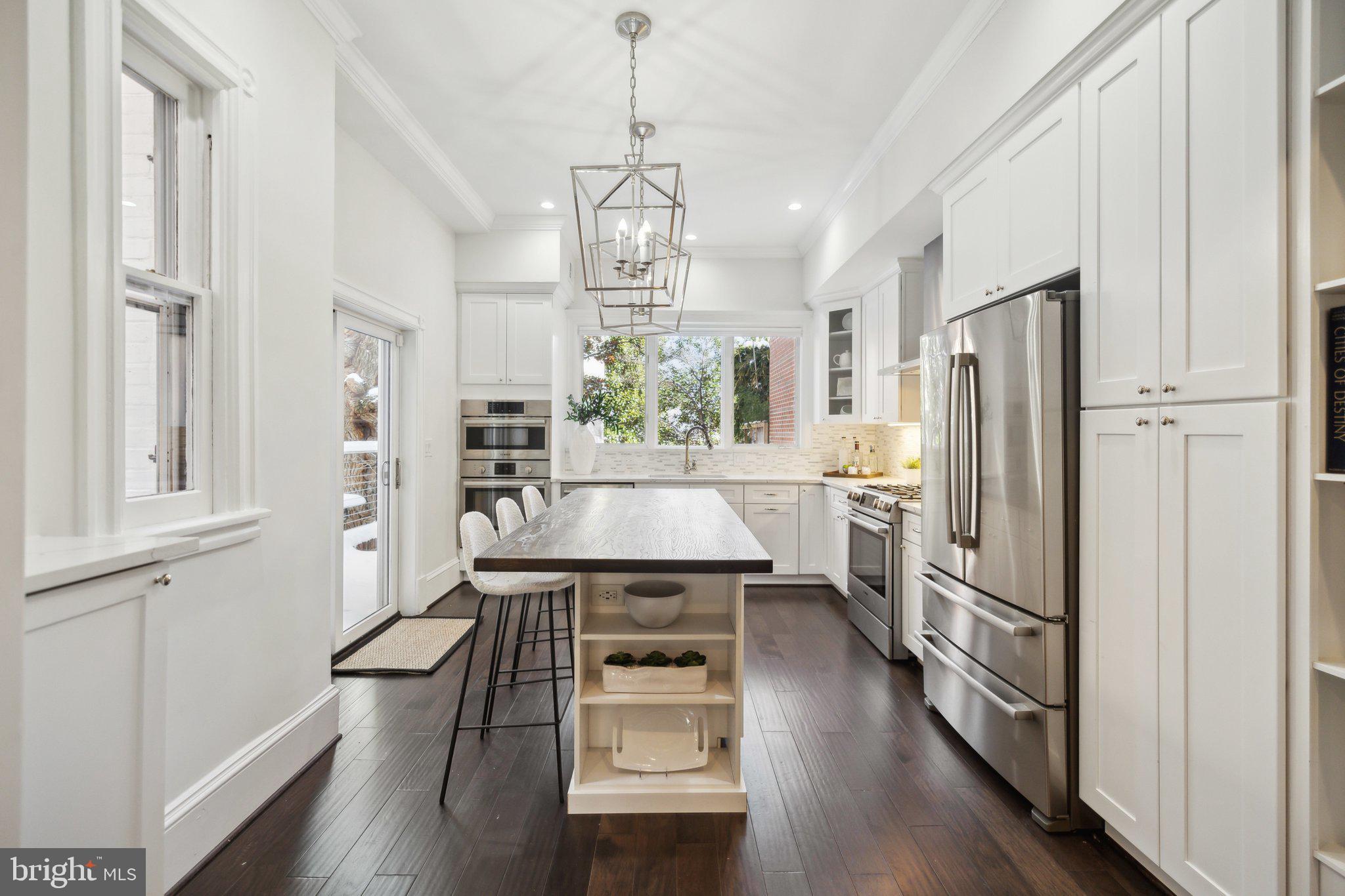 1527 31st Street Northwest Washington, DC 20007 - Photo 9 of 29 a kitchen with stainless steel appliances a refrigerator a sink dishwasher a stove and white cabinets with wooden floor