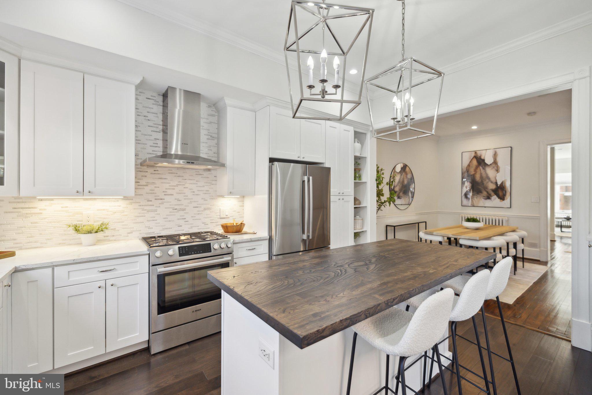1527 31st Street Northwest Washington, DC 20007 - Photo 10 of 29 a kitchen with stainless steel appliances granite countertop a kitchen island a stove a table and chairs in it