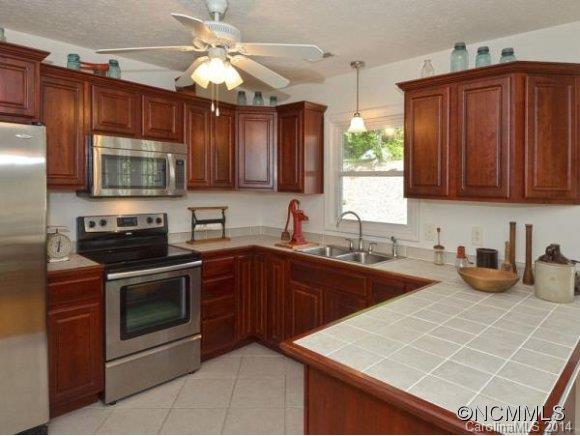 3964 Liner Creek Road Clyde, NC 28721 - Photo 2 of 17 a kitchen with stainless steel appliances a stove sink microwave and cabinets