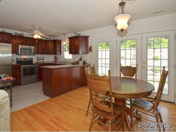 3964 Liner Creek Road Clyde, NC 28721 - Photo 3 of 17 a kitchen with stainless steel appliances granite countertop a sink dishwasher a stove a refrigerator with a dining table and chairs