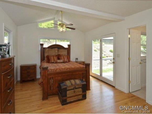 3964 Liner Creek Road Clyde, NC 28721 - Photo 8 of 17 a bedroom with a bed and a chandelier