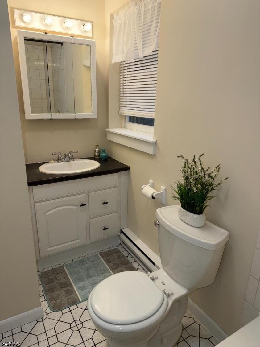 6 Southard Road, Unit 2 Mount Arlington, NJ 07856 - Photo 8 of 10 a bathroom with a toilet a sink and mirror