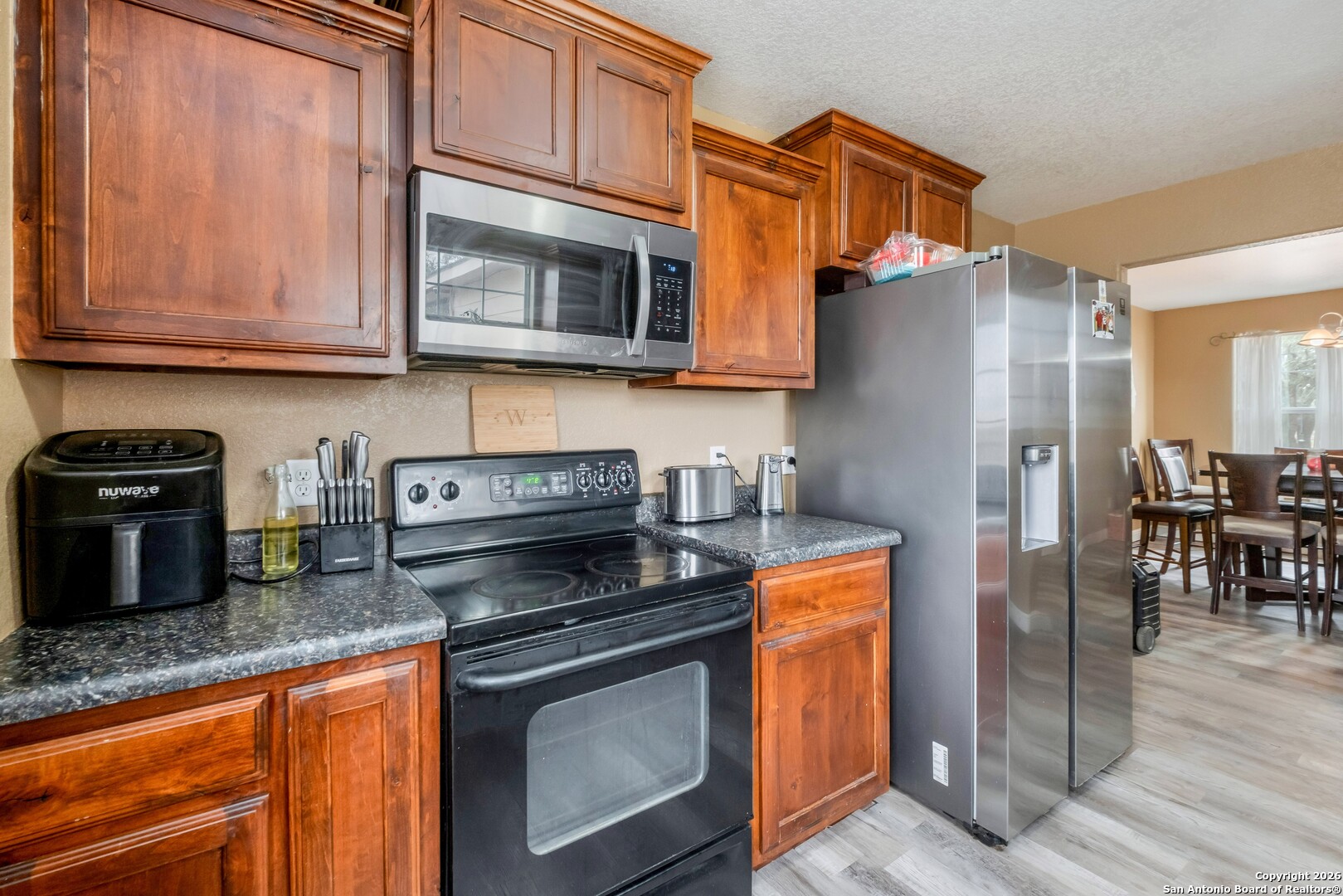 1655 Eichman Road Poteet, TX 78065 - Photo 13 of 45 a kitchen with stainless steel appliances granite countertop a stove a refrigerator and a microwave