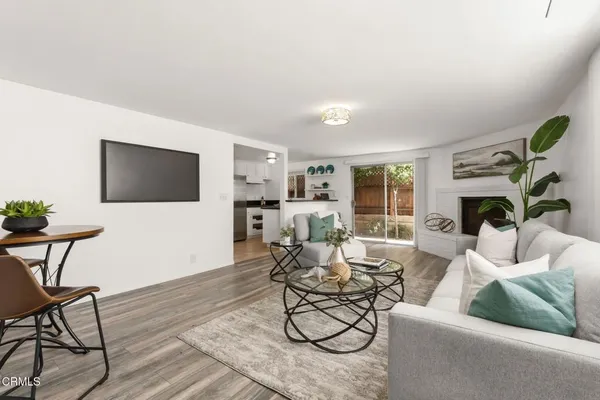 a living room with stainless steel appliances granite countertop furniture and a fireplace