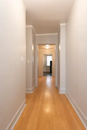 a view of a hallway with wooden floor