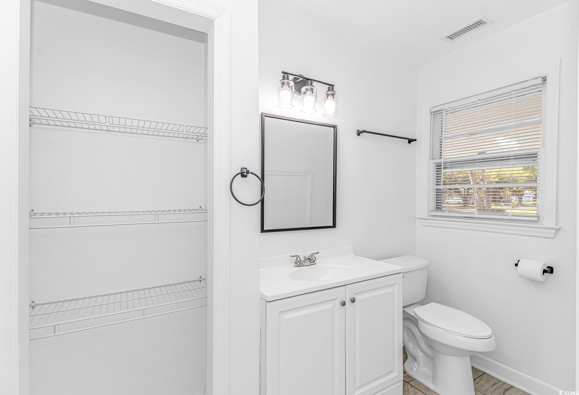 1931 Jasper Street Georgetown, SC 29440 - Photo 18 of 30 Bathroom with baseboards, toilet, vanity, a walk i